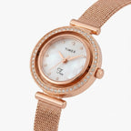 A women's Timex watch with a rose gold mesh strap, a round bezel encrusted with small clear crystals, and a white mother-of-pearl dial with rose gold hands.
