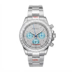 A silver stainless steel wristwatch with a diamond-encrusted bezel, a silver dial covered in small diamonds, and three light blue chronograph sub-dials. The brand name 'Kelly Dutton' is visible on the dial, and '1904L' is printed in red on the bracelet links.