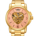 A gold-tone stainless steel wristwatch with a rose gold dial featuring a skeletonized center showing the mechanical movement. The brand name 'WINNER' is printed above the center dial.