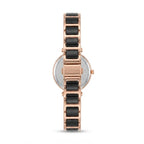 A women's analog watch by Discovery, shown from the back. It features a rose gold-tone metal case and link bracelet with black rectangular inlay segments, a silver-tone circular dial, and a crown on the right side.