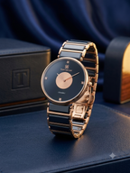 A luxury ceramic and rose gold watch by Time Square, displayed on a dark blue leather surface with a matching branded box in the background.