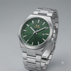 A high-end professional product photograph of a HILTER men's watch. The watch has a stainless steel case and a matching integrated steel bracelet, presented against a neutral, light grey background. The dial is a deep, rich green sunray color with applied silver-tone baton hour indices and matching luminous hands. The HILTER logo is prominently displayed in gold at the 12 o'clock position, and a date window is located at 3 o'clock, showing the date '26'. The watch is captured from an elegant, slightly eleva