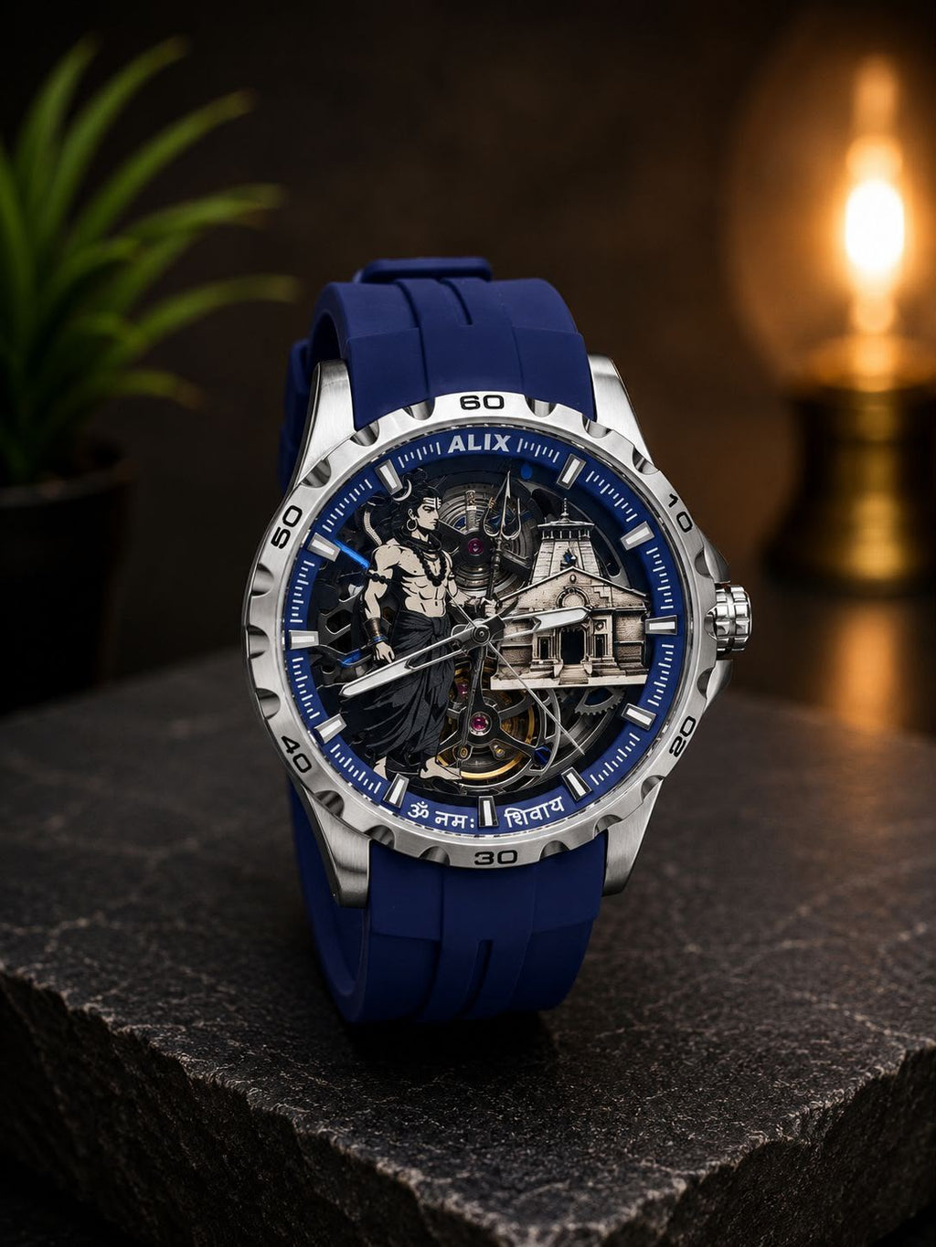A luxury skeleton watch with a blue silicone strap and a detailed silver-tone case, displayed on a dark stone surface with a warm, blurred background.