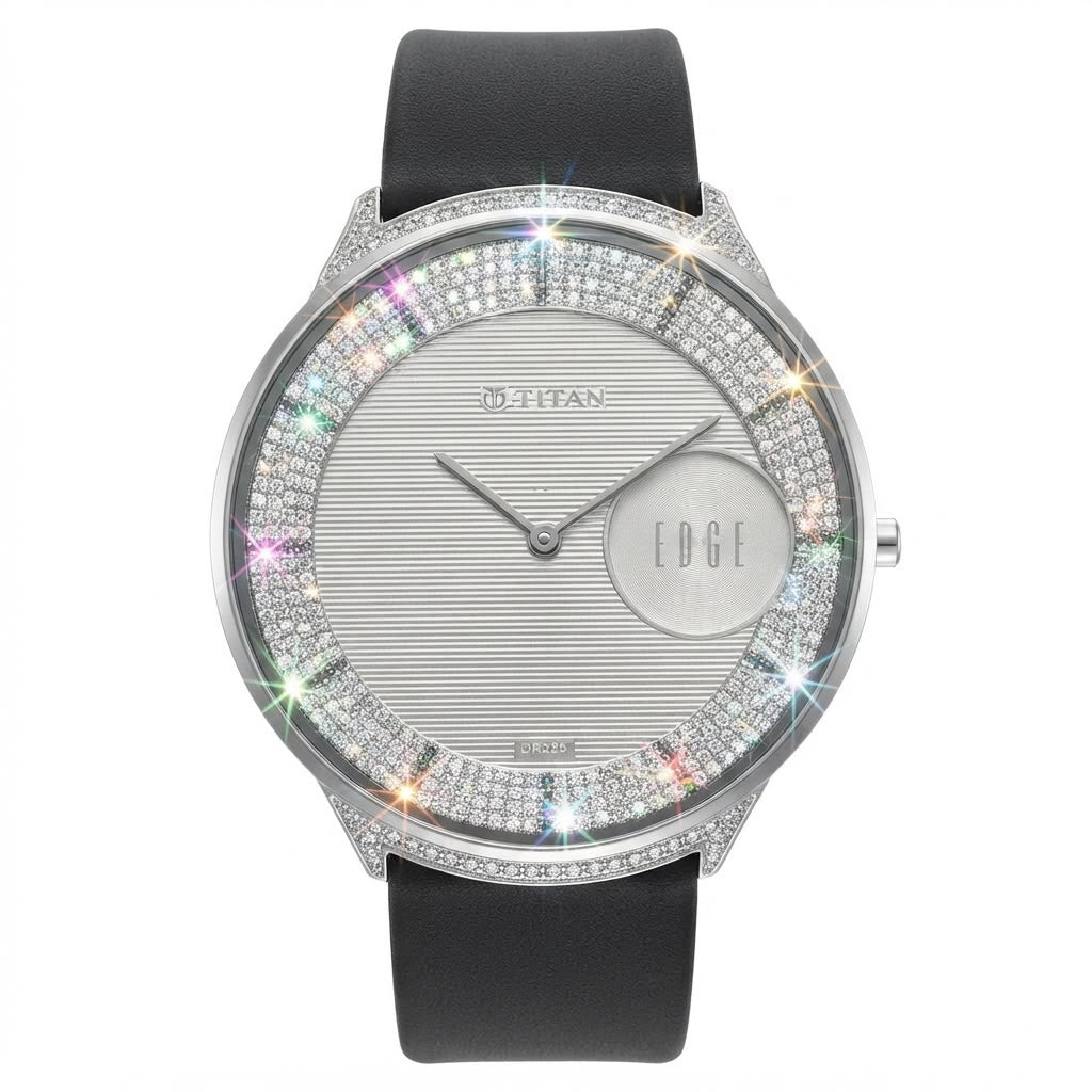 A Mithan Edge watch featuring a silver-toned dial with a textured center, a circular date window, and a bezel encrusted with sparkling clear stones that reflect rainbow light. The watch has a black leather strap and is shown against a plain white background.