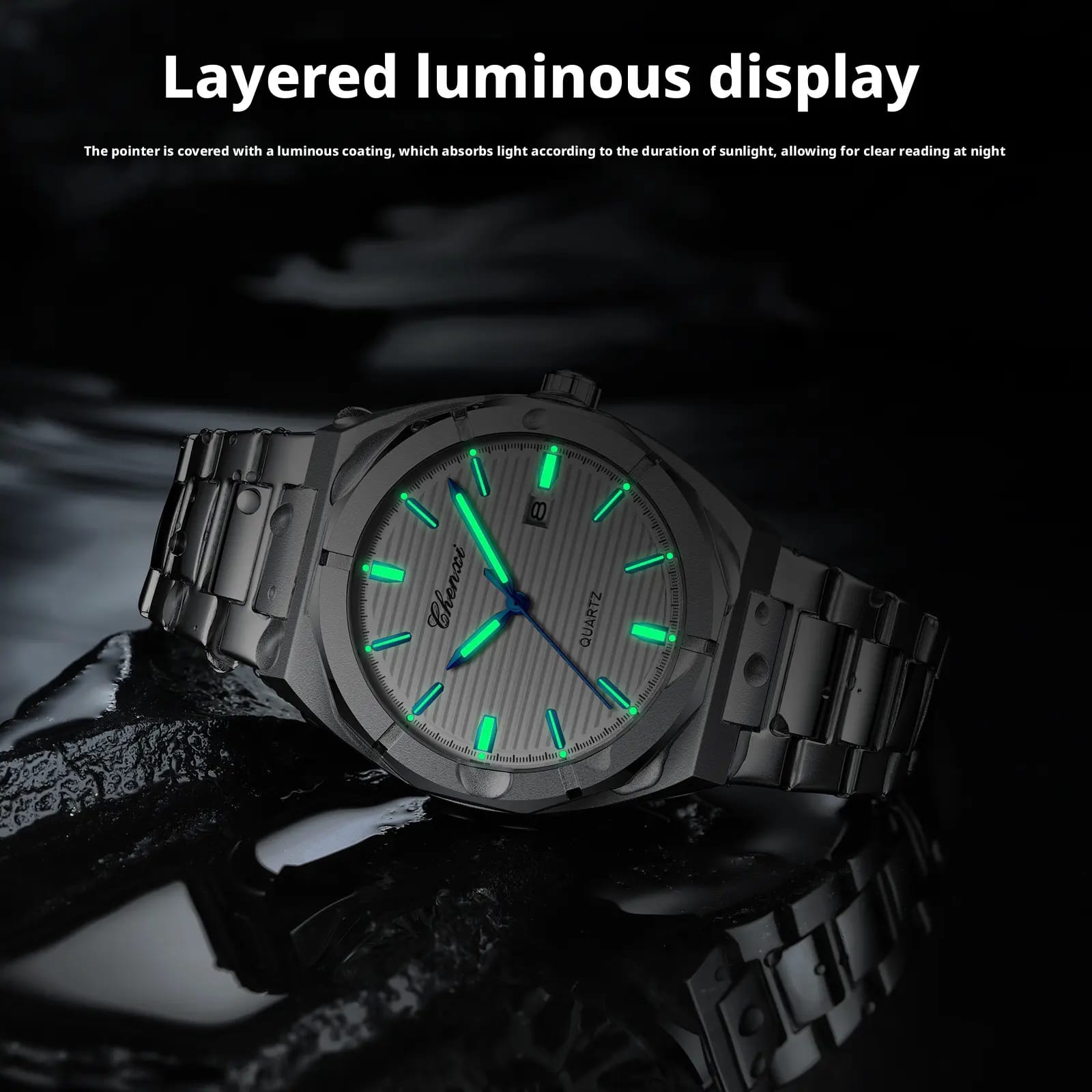 A stainless steel wristwatch with a luminous gray dial and green glowing markers, displayed on a dark reflective surface with promotional text at the top.