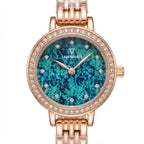 A Fairwhale women's watch featuring a rose gold-tone metal bracelet and case, a bezel encrusted with clear crystals, and a vibrant blue and green marbled dial with crystal hour markers.