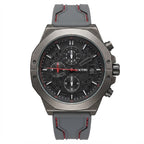 A men's chronograph watch with a dark gray metallic case, a black dial with three subdials, and a gray rubber strap with red stitching, shown against a plain white background.