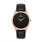 A minimalist wristwatch with a black dial, rose gold case, and a black textured leather strap, shown against a plain white background.